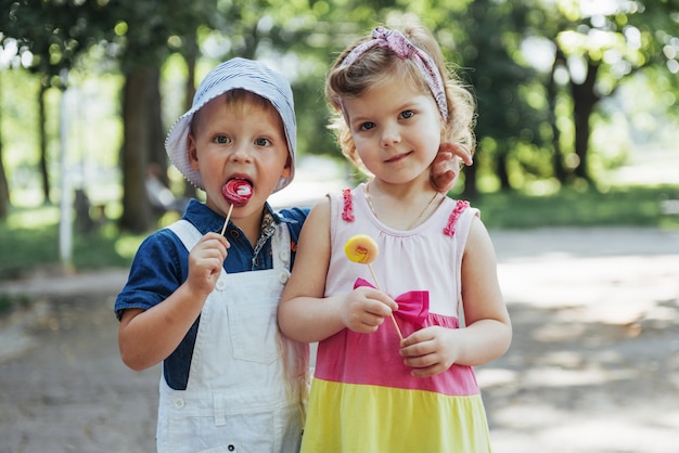 Niños felices prueban dulces en un palo