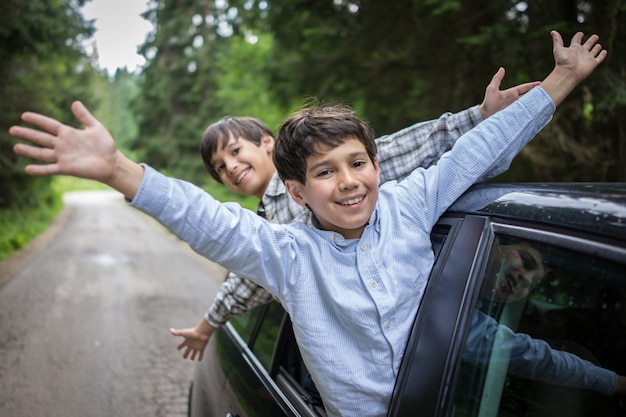 Niños felices que viajan en auto