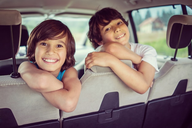 Niños felices que viajan en auto