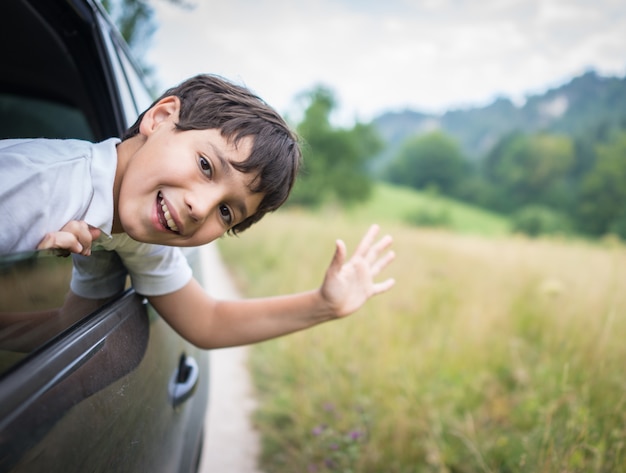 Niños felices que viajan en auto