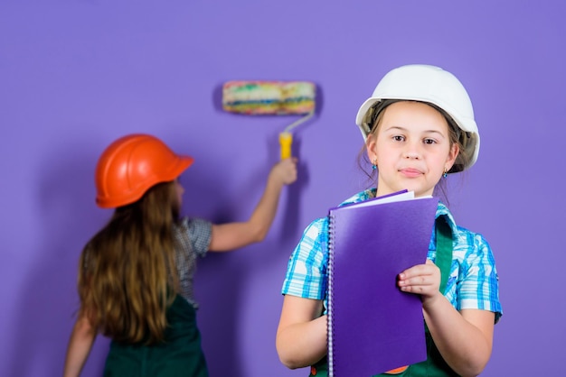 Niños felices renovando el hogar Repintar paredes Actividad de mejoras para el hogar Niños niñas planeando la renovación El violeta es mi color favorito Niños hermanas renovando su habitación Controlar el proceso de renovación