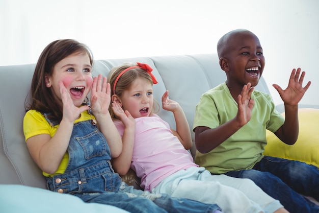 Niños felices riendo mientras se sientan