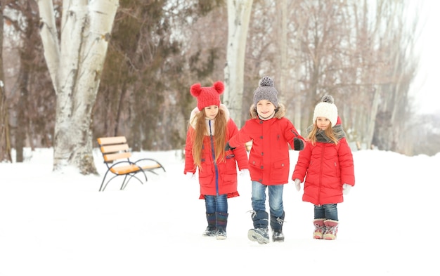 Niños felices en ropa de abrigo roja divirtiéndose al aire libre en invierno