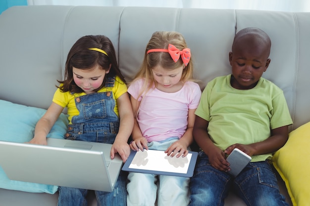 Niños felices sentados junto con una tableta