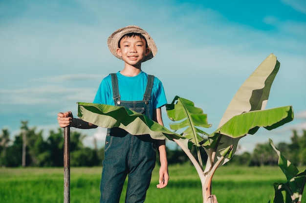 Los niños felices sonríen y plantan el árbol en el campo