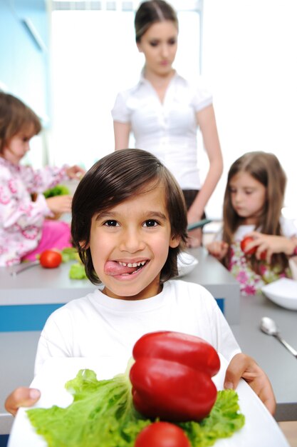 Foto niños felices con su madre en la cocina juntos