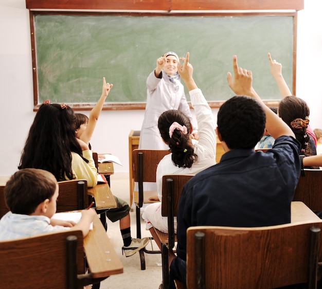 Niños felices con su maestro en el aula, haciendo