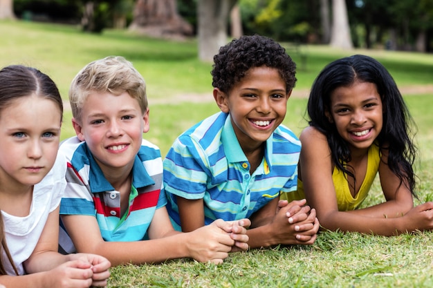 Niños felices tirado en el pasto