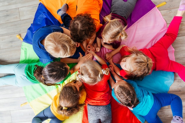 Niños felices tirados en el suelo en círculo