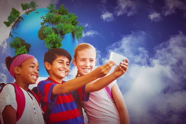 Foto niños felices tomando selfie en el pasillo de la escuela contra la tierra generada digitalmente flotando en el aire