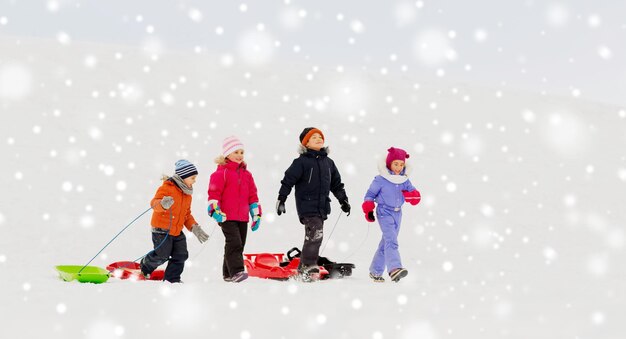 niños felices con trineos en invierno