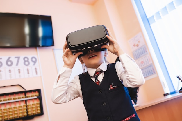 Los niños con gafas de realidad virtual están en la oficina de la escuela.