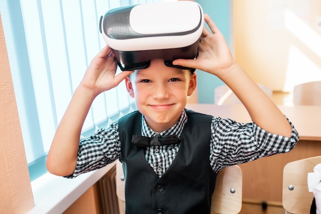 Los niños con gafas de realidad virtual están en la oficina de la escuela.