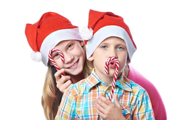 Niños con gorras rojas con dulces navideños aislados