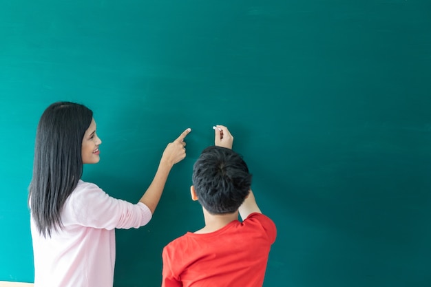 niños greenboard escribiendo iin escuela de verano