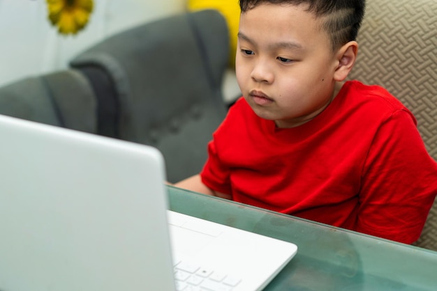 Los niños hacen educación mediante el aprendizaje en línea con una computadora portátil o tableta en casa en cuarentena llamada comunicación de aprendizaje electrónico al maestro o tutor
