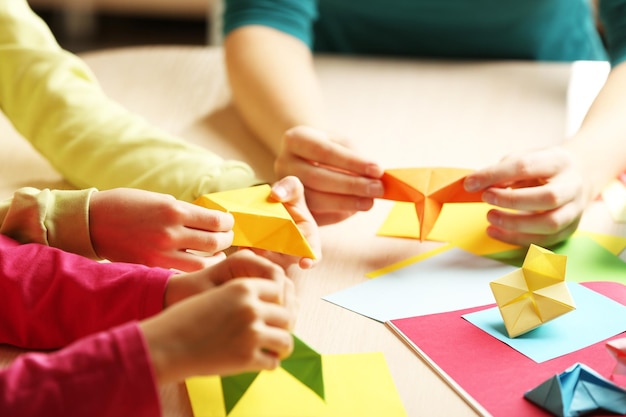 Niños haciendo cisne con papel de colores