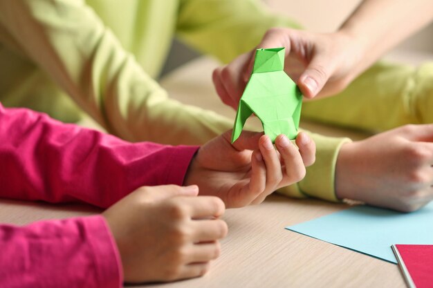 Niños haciendo cisne con papel de colores