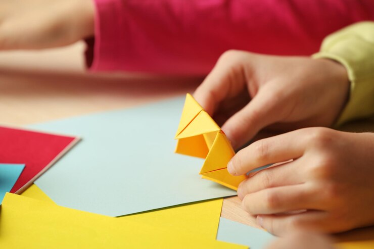 Foto niños haciendo un cisne con papel de colores
