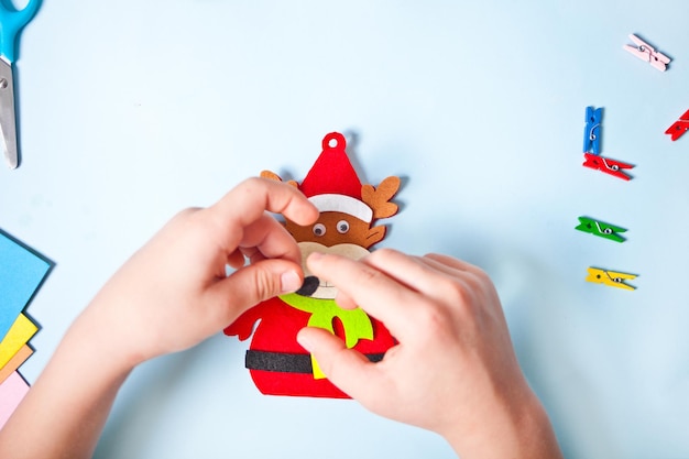 Niños haciendo decoración de ciervos para árbol de Navidad o regalos Proyecto de bricolaje hecho a mano de Navidad