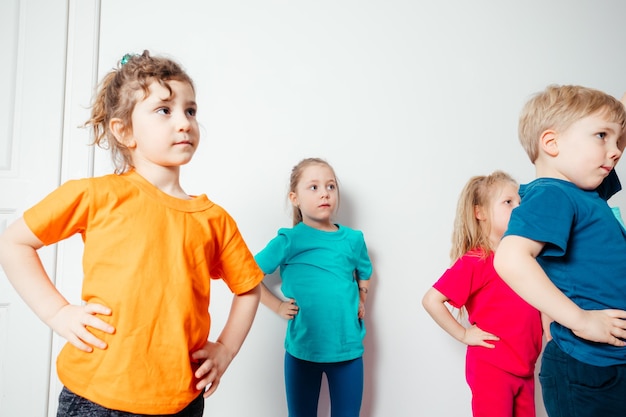 Niños haciendo ejercicios de estiramiento antes del entrenamiento gimnástico