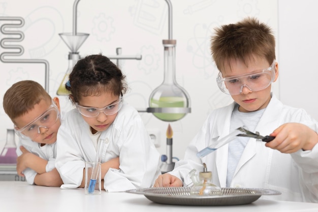 Foto niños haciendo un experimento químico en la escuela.