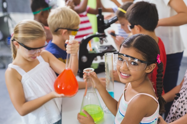 Foto niños haciendo un experimento químico en laboratorio