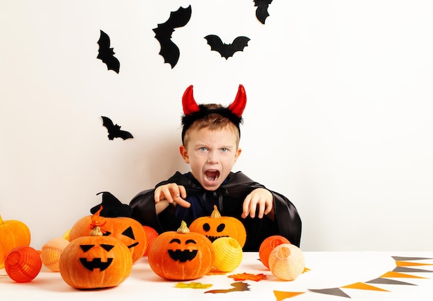 Niños en Halloween Chico divertido en un disfraz de Halloween y cuernos de diablo Feliz Halloween