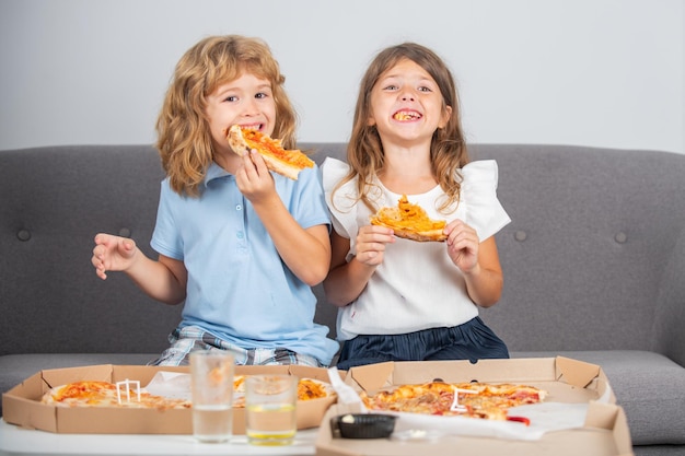 Niños hambrientos comiendo pizza niña y niño comen pizza