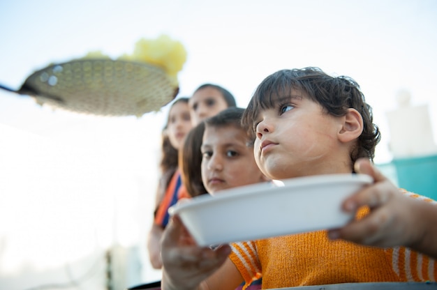 Niños hambrientos siendo alimentados por caridad