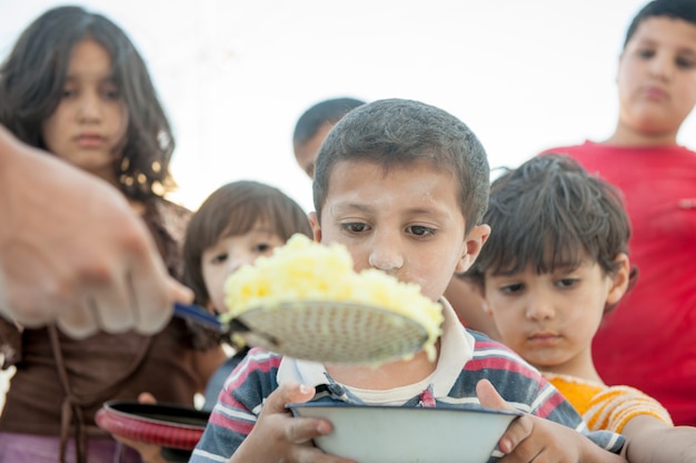 Niños hambrientos siendo alimentados por caridad