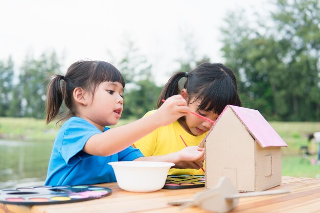 Niños hermanos asiáticos dibujando y pintando para colorear