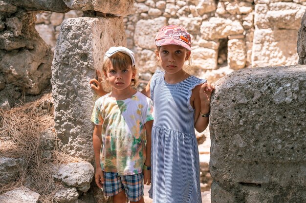 Niños hermanos, niñas y niños viajeros viajan y exploran las antiguas excavaciones de las ruinas de la antigua ciudad licia de Phaselis en Turquía durante las vacaciones de verano en la naturaleza en las montañas al aire libre