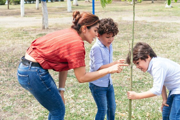 Niños hispanos jugando con su madre durante un paseo por el parque