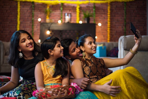 Los niños indios celebrando Diwali, Deepawali, Bhai Dooj o Rakhi o Raksha Bandhan con flor rangoli, regalos, diya