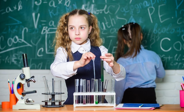 Niños inteligentes y confiados Estudiantes de lecciones de química haciendo experimentos de biología con microscopio en el laboratorio Niños pequeños aprendiendo química en el laboratorio de la escuela Equipo de química Educación química