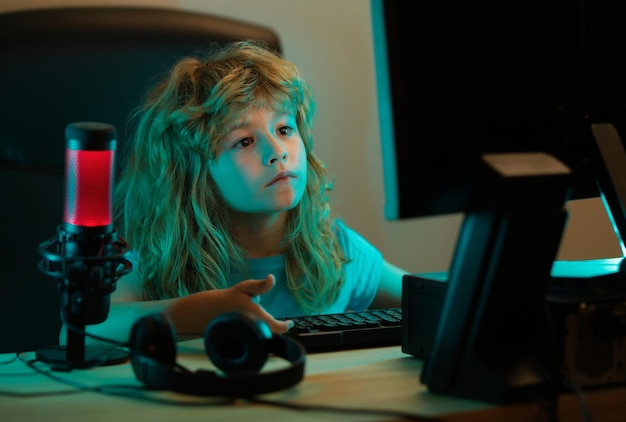 Niños inteligentes que aprenden en línea en casa Niño caucásico que trabaja en una computadora portátil en una habitación oscura por la noche Estudio escolar concepto de aprendizaje en línea