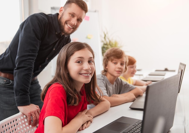 Foto niños inteligentes que estudian programación en el aula.