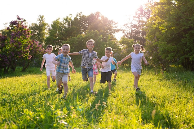 Los niños juegan al aire libre corriendo y divirtiéndose en un campo de hierba