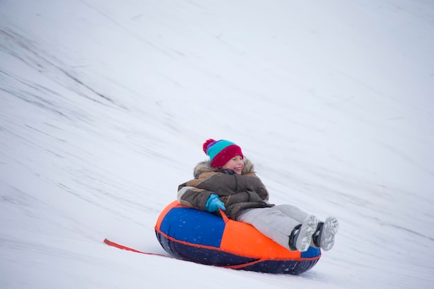 Los niños juegan al aire libre en la nieve Trineo de niños en las montañas de los Alpes en w