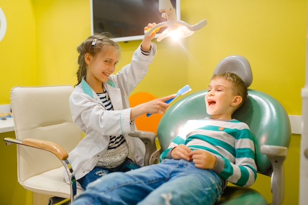 Los niños juegan al trabajador de la medicina en un hospital imaginario