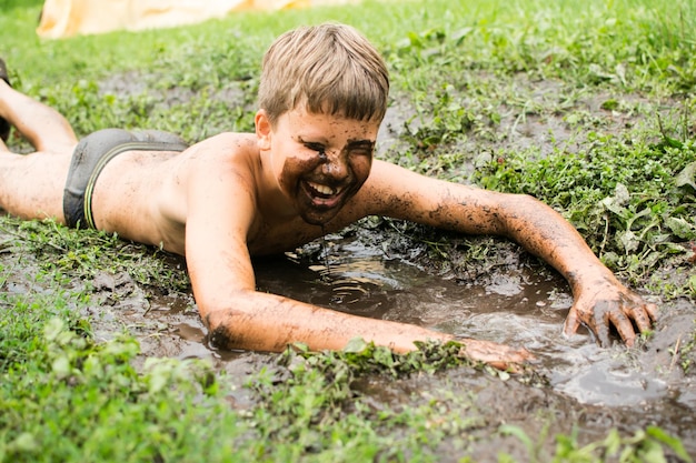 Los niños juegan en un charco, se untan en el barro. Todo sucede durante las vacaciones de verano en popa.