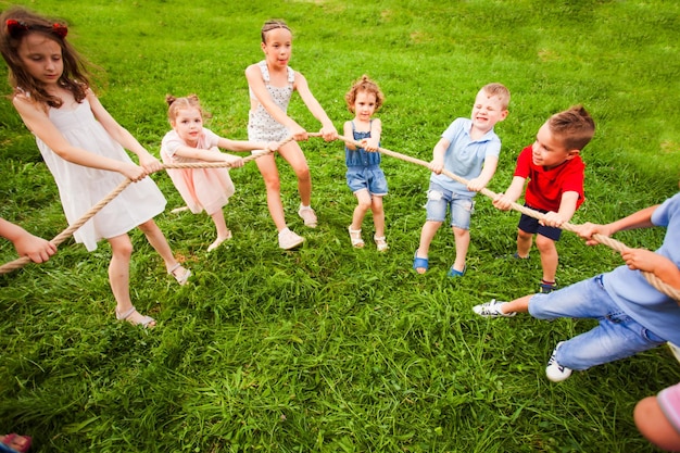 Los niños juegan con una cuerda crean un círculo al aire libre Concepto de juegos deportivos