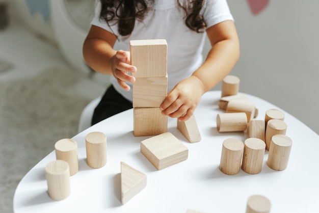 Los niños juegan con juguetes de madera en la habitación de los niños.