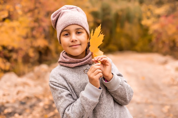 Foto los niños juegan en el parque de otoño. niños tirando hojas amarillas. niña niño con hoja de arce. follaje de otoño. diversión familiar al aire libre en otoño. niño pequeño o preescolar en otoño