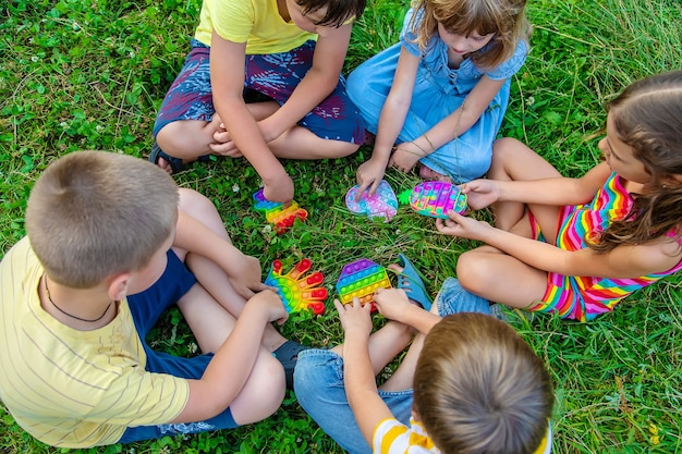 Los niños juegan popit antiestrés en la calle. Enfoque selectivo. Niños.