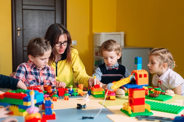 Niños jugando con bloques constructores en clase.