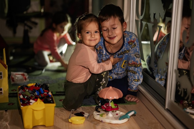 Niños jugando en casa durante un apagón usando iluminación alternativa