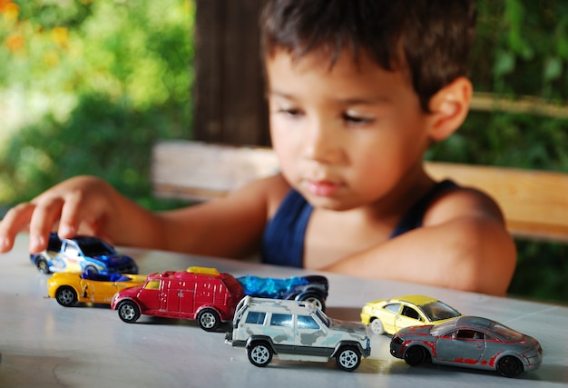 Niños jugando con coches juguetes al aire libre en verano