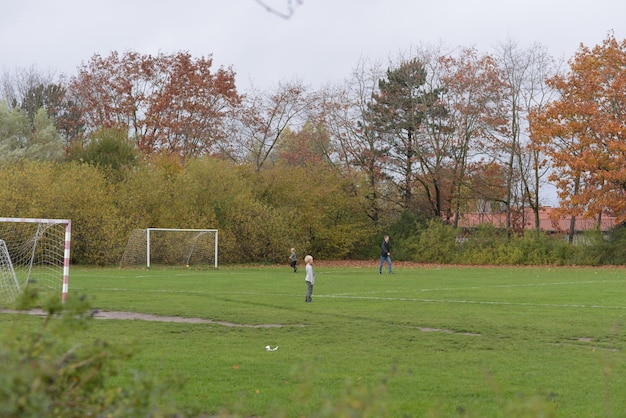 Niños jugando en un gran parque con su padre.